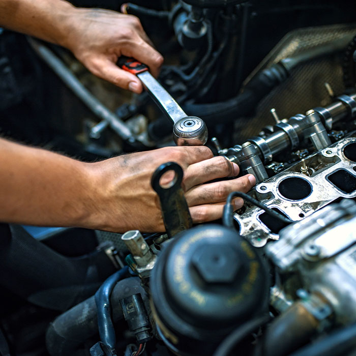 Car mechanic man at the garage fixing the engine