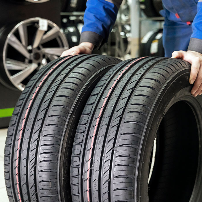 The seller rolls a pair of new tires for the season to the store's exit