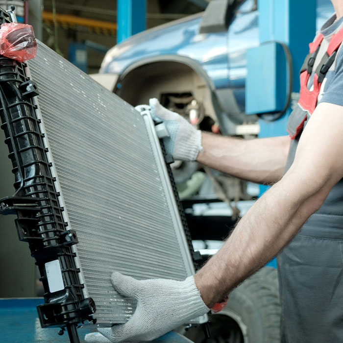 In the hands of an auto mechanic, an automobile radiator