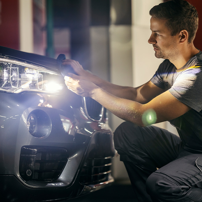 A car wash worker is polishing a car at station