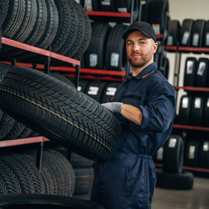 Man worker is maintenance station with tires